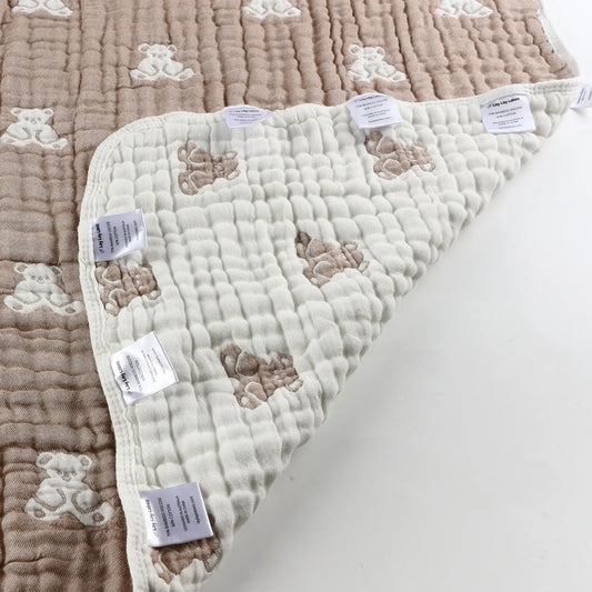 Close-up of teddy baby blanket corner showing soft textured fabric and sensory labels