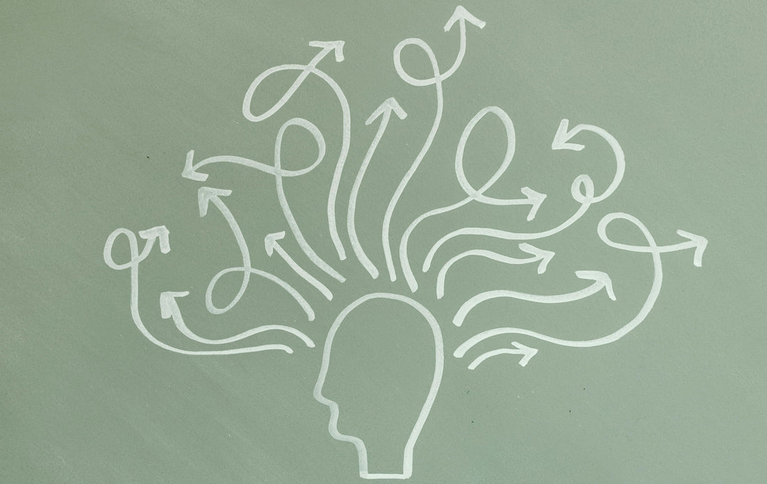 The image shows a simple chalk drawing of a head outline with many arrows swirling and branching out in different directions from it, symbolising busy thoughts, distraction, or multiple thought paths.