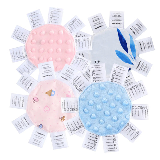 Lay Lay Mini sensory tag toys in pink and blue minky dot and printed fabrics, each ringed with soft clothing-style labels for little hands