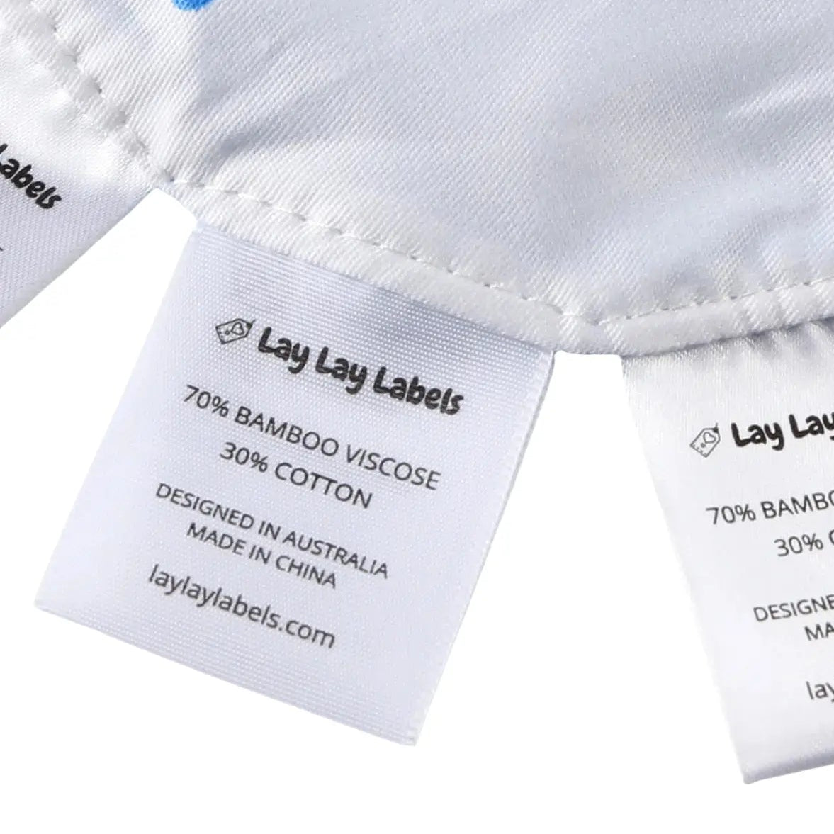 Close-up of silk and woven sensory labels on blue baby minis showing texture contrast