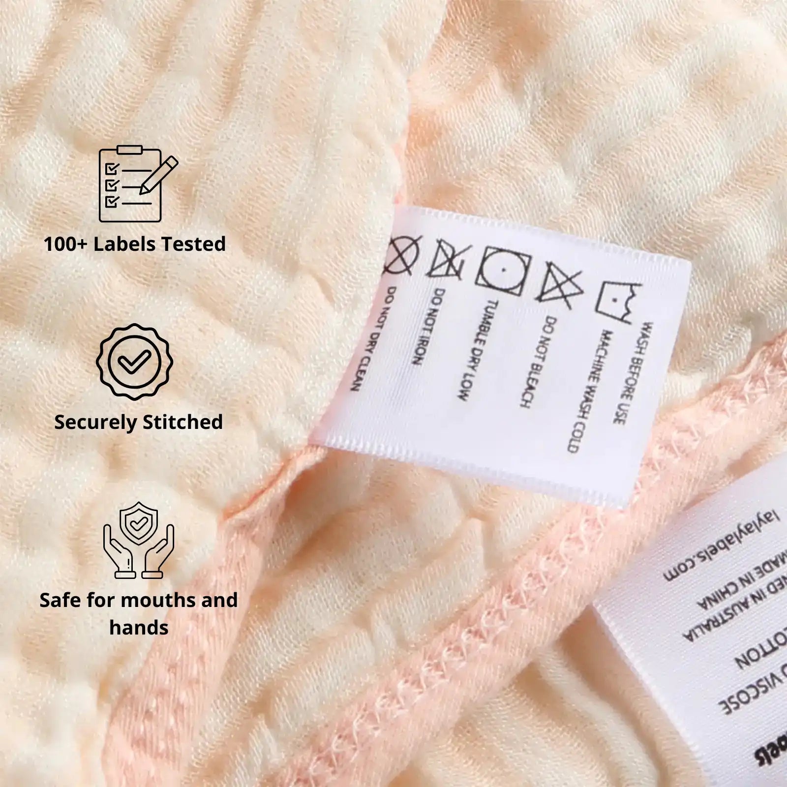 Close-up of pink baby blanket label showing stitched tag and safety features for everyday use