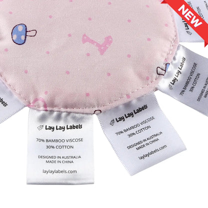 Close-up of silk and woven sensory labels on pink baby minis showing texture contrast