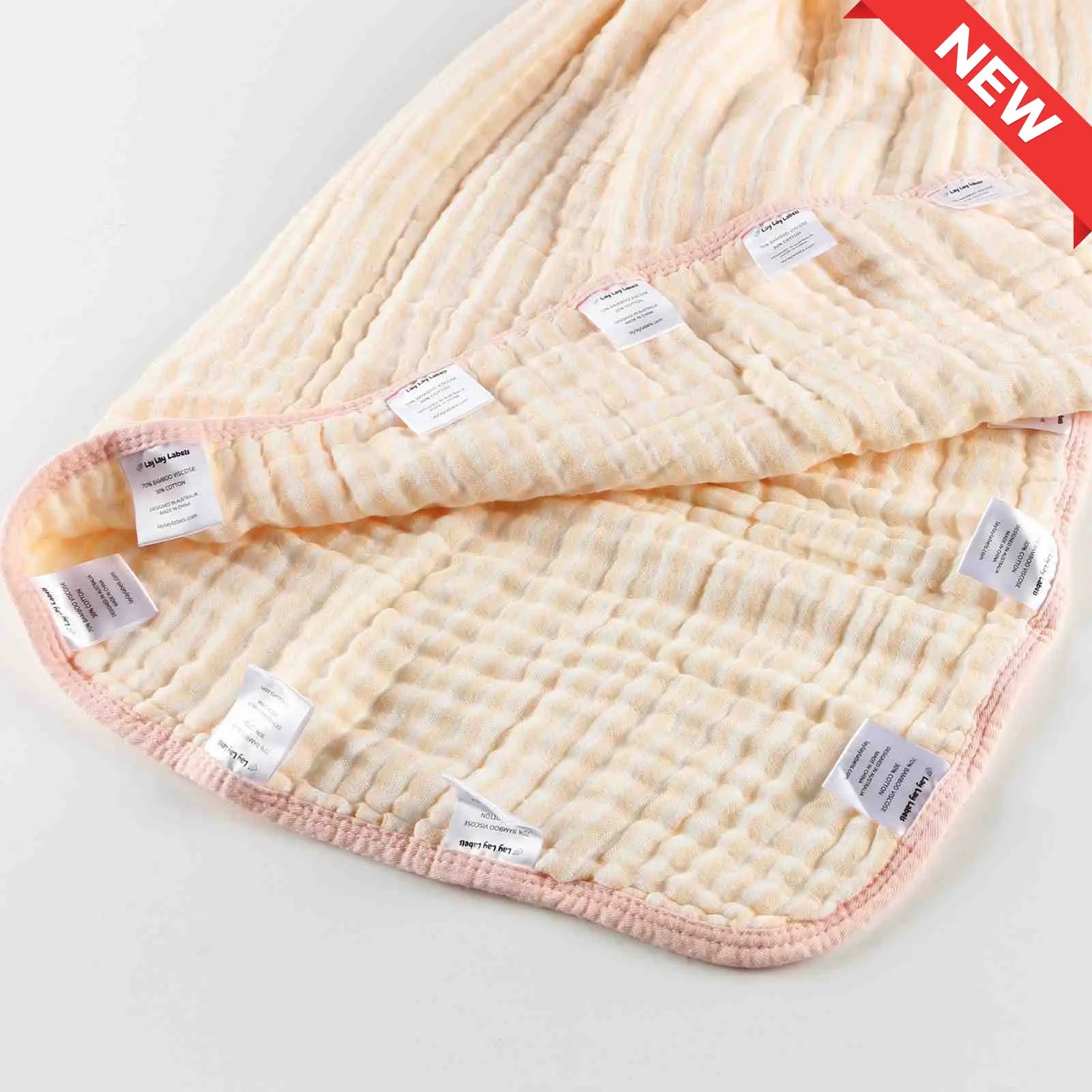 Pink baby blanket with soft fabric and textured silk labels for sensory comfort