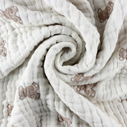 Close-up of teddy baby blanket fabric showing soft textured muslin with teddy pattern