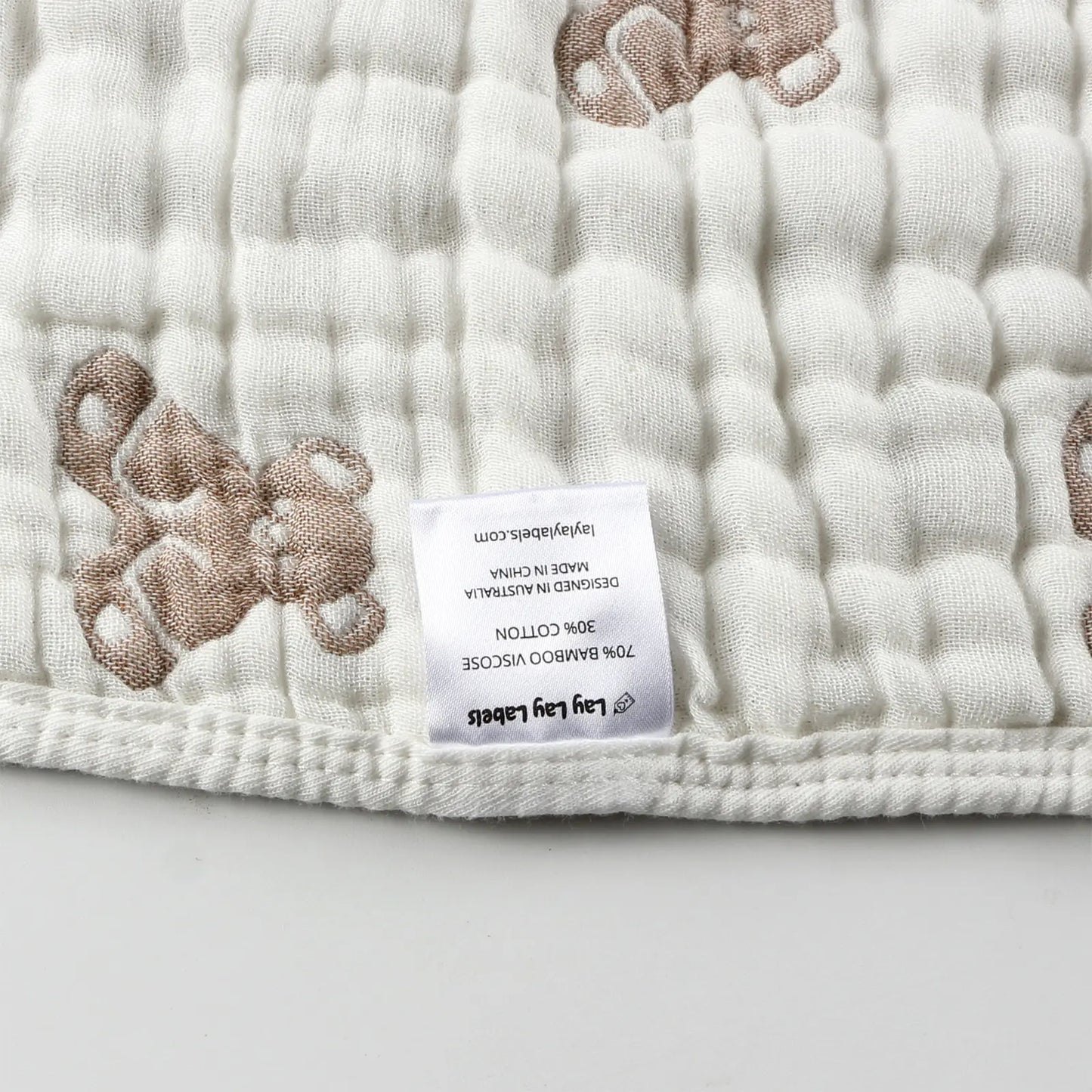 Close-up of sensory labels on teddy baby blanket showing soft fabric and stitched tags