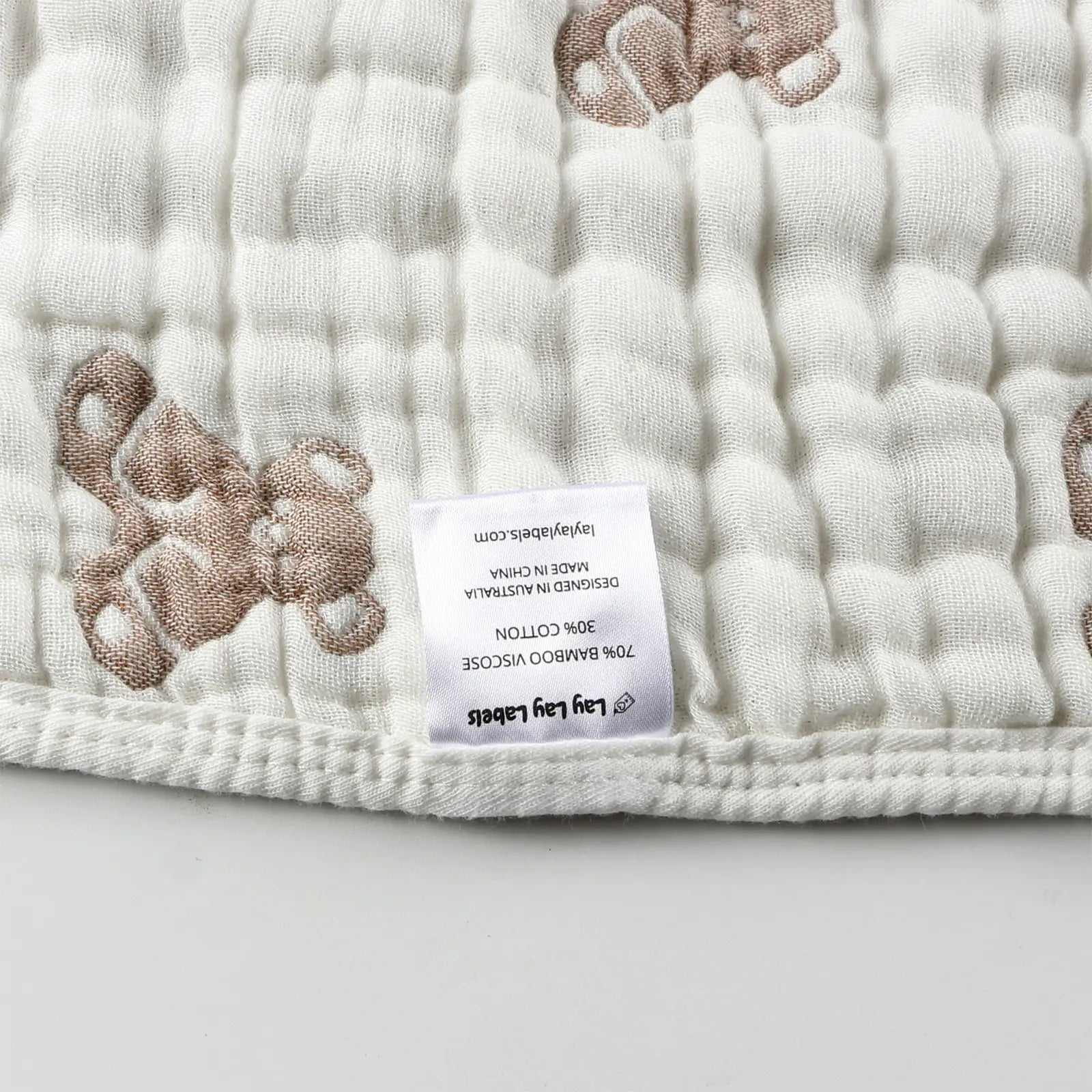 Close-up of sensory labels on teddy baby blanket showing soft fabric and stitched tags