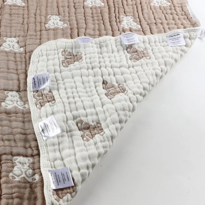 Close-up of teddy baby blanket corner showing soft textured fabric and sensory labels