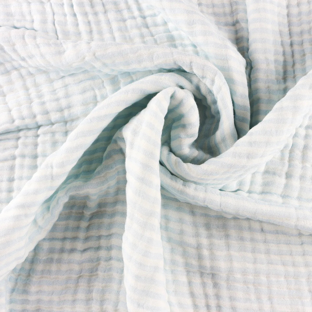 Close-up of the blanket's crinkled bamboo muslin swirled into a spiral