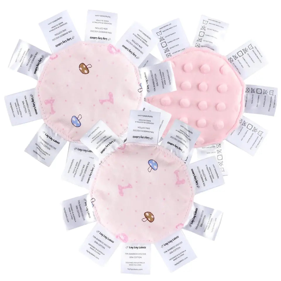 Three pink Lay Lay Minis, round comforters edged with white labels